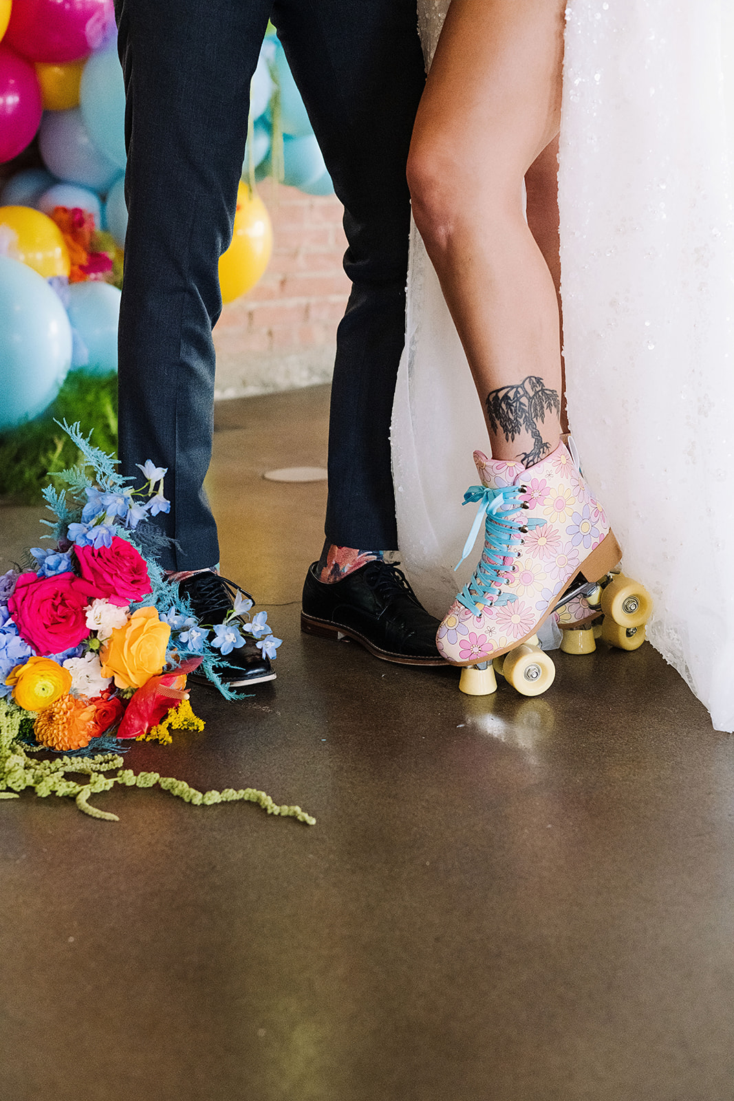 Bride wears floral roller skates as part of a colorful wedding day. Groom wears matching floral socks. Bouquet placed near shoes. #Kaushay&Co #Kaushay&CoWeddings #Wedding #ColorfulWedding #UtahWeddings #weddingplannerutah #Utahweddingplanner #NorthernUtahEventPlanner